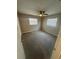 Cozy bedroom with carpet, ceiling fan, and two windows at 608 Lemonwood Dr, Oldsmar, FL 34677