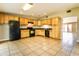 Well-lit kitchen featuring tile floors, wooden cabinets, and black appliances at 608 Lemonwood Dr, Oldsmar, FL 34677