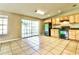 Bright kitchen with tile floors and access to backyard, featuring wooden cabinets and black appliances at 608 Lemonwood Dr, Oldsmar, FL 34677