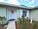 Close-up of the front door with white trim and a storm door, framed by manicured bushes and a bird bath at 612 Bryan Terrace Dr, Brandon, FL 33511