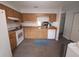 Clean kitchen featuring white appliances, wood cabinets, neutral tile floors, and bright lighting at 612 Bryan Terrace Dr, Brandon, FL 33511