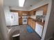Modern kitchen with white appliances, light wood cabinets, and gray tile flooring at 612 Bryan Terrace Dr, Brandon, FL 33511