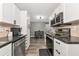 Modern kitchen featuring white cabinets, stainless steel appliances, and an open view of the dining area at 6511 Georgia Ave, Bradenton, FL 34207