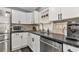 Updated kitchen features white cabinets, black countertops, stainless steel appliances, and modern fixtures at 6511 Georgia Ave, Bradenton, FL 34207