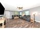 Spacious living room with dark furniture, wood floors, a ceiling fan, and a sliding barn door at 6511 Georgia Ave, Bradenton, FL 34207