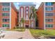 Exterior view of condo building featuring a grand entrance, well-manicured lawn, and tropical landscaping at 6800 20Th N Ave # 307, St Petersburg, FL 33710