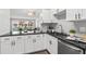 Modern kitchen features white cabinets, stainless appliances, dark granite countertops and stylish tile backsplash with bar seating at 6800 20Th N Ave # 307, St Petersburg, FL 33710