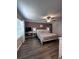 Bedroom features desk, ceiling fan, and wood-look floors at 6942 Ripple Pond Loop, Zephyrhills, FL 33541