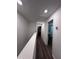 Hallway featuring wood floors and recessed lighting, leading to various rooms at 6942 Ripple Pond Loop, Zephyrhills, FL 33541