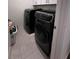 Convenient laundry room featuring modern, black washer and dryer at 6942 Ripple Pond Loop, Zephyrhills, FL 33541