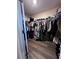 Walk-in closet with ample storage space and wood-look floors at 6942 Ripple Pond Loop, Zephyrhills, FL 33541