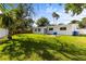 Lush backyard featuring a spacious lawn, a patio area, mature trees and a painted white house at 722 61St S Ave, St Petersburg, FL 33705