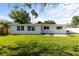 Spacious backyard featuring an established lawn, mature trees, a patio area, and the home's rear exterior at 722 61St S Ave, St Petersburg, FL 33705
