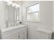 Bright bathroom featuring a white vanity, decorative mirror, and a window providing natural light at 722 61St S Ave, St Petersburg, FL 33705