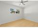 Minimalist bedroom featuring light wood flooring, a ceiling fan, and a large window providing natural light at 722 61St S Ave, St Petersburg, FL 33705