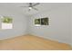 Bright, airy bedroom with hardwood floors, white walls, ceiling fan, and two windows offering exterior views at 722 61St S Ave, St Petersburg, FL 33705
