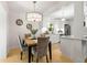 Bright dining room with a modern chandelier and views of the adjacent, updated kitchen with white cabinets at 722 61St S Ave, St Petersburg, FL 33705