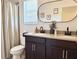 Well-lit bathroom featuring a double vanity with dark wood cabinets and framed mirror at 7704 Tuscany Woods Dr, Tampa, FL 33647