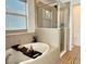 Ceramic tiled bathroom featuring an alcove tub and walk-in shower with glass enclosure at 7704 Tuscany Woods Dr, Tampa, FL 33647