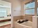Inviting bathroom featuring luxurious soaking tub with stylish bath caddy and neutral-toned tile at 7704 Tuscany Woods Dr, Tampa, FL 33647