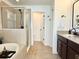Bright bathroom with walk-in shower, soaking tub, dark cabinets, and ceramic tile flooring at 7704 Tuscany Woods Dr, Tampa, FL 33647