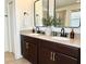 Modern bathroom featuring double vanity with dark wood cabinets and matte black faucet fixtures at 7704 Tuscany Woods Dr, Tampa, FL 33647
