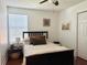 Bright bedroom with window, ceiling fan, hardwood floors, and comfortable furniture at 7704 Tuscany Woods Dr, Tampa, FL 33647