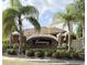 Community entrance sign surrounded by palm trees and manicured landscaping at 7704 Tuscany Woods Dr, Tampa, FL 33647