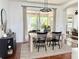 Dining area with modern light fixture, neutral walls, and view to patio at 7704 Tuscany Woods Dr, Tampa, FL 33647
