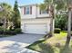Charming two-story home with a two car garage, paver driveway, and lush tropical landscaping at 7704 Tuscany Woods Dr, Tampa, FL 33647