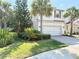 Charming two-story home with a two car garage, paver driveway, and lush landscaping at 7704 Tuscany Woods Dr, Tampa, FL 33647