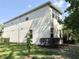 Rear exterior of the house with a large yard and stucco facade at 7704 Tuscany Woods Dr, Tampa, FL 33647