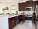 Bright kitchen with stainless steel appliances, tile flooring, and dark wood cabinets at 7704 Tuscany Woods Dr, Tampa, FL 33647