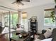 Bright living room features sliding doors to patio, ceiling fan, stylish decor, and wood floors at 7704 Tuscany Woods Dr, Tampa, FL 33647