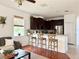 Open floorplan showing living room transitioning to kitchen with breakfast bar and dark cabinetry at 7704 Tuscany Woods Dr, Tampa, FL 33647