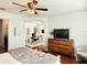Bright main bedroom featuring modern ceiling fan, accent furniture and view to adjacent office at 7704 Tuscany Woods Dr, Tampa, FL 33647