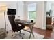 Home office with modern desk, leather chair, natural light, and neutral rug at 7704 Tuscany Woods Dr, Tampa, FL 33647