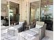 Cozy patio setup with cushioned wicker chairs, ottomans, and access to home's interior through sliding glass doors at 7704 Tuscany Woods Dr, Tampa, FL 33647