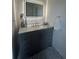 Bathroom vanity with gray cabinets, marble top, and lighted mirror at 8050 Roxburgh Ct, Weeki Wachee, FL 34613