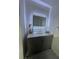 Bathroom with a stylish gray vanity, marble top, and lighted mirror at 8050 Roxburgh Ct, Weeki Wachee, FL 34613