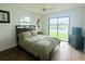 Serene bedroom with a large bed and sliding glass door, offering serene backyard views at 8050 Roxburgh Ct, Weeki Wachee, FL 34613