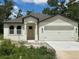 Charming single-story home featuring a two-car garage and a welcoming front entrance with an unfinished lawn at 8149 Cashew, Webster, FL 33597