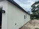 Side view of a white home exterior with a dark roof and manicured lawn at 8149 Cashew, Webster, FL 33597