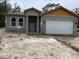 Charming single-story home with gray stucco exterior and attached garage, ready for landscaping at 8149 Cashew, Webster, FL 33597