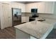 Bright kitchen features white cabinets, stainless steel appliances, and a large granite countertop island at 8149 Cashew, Webster, FL 33597