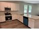 Well-lit kitchen showcases white cabinets, granite countertops, stainless steel appliances, and hardwood flooring at 8149 Cashew, Webster, FL 33597