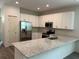Bright kitchen boasts white cabinets, stainless steel appliances, granite countertops, and hardwood floors at 8149 Cashew, Webster, FL 33597