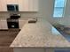 Modern kitchen with stainless steel appliances, white cabinets, and a granite countertop at 8149 Cashew, Webster, FL 33597