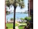 Lovely view of waterfront with mature palm trees and manicured grounds at 8931 Blind Pass Rd # 257, St Pete Beach, FL 33706