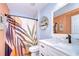 Bathroom features a shower with stylish curtain, white vanity, and decorative mirror at 9304 Lake Chase Island Way, Tampa, FL 33626